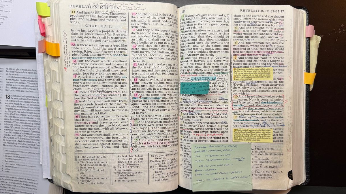 Kelly Smith’s well-worn scriptures open to Revelation chapters 11 and 12, covered in colored highlights, sticky tabs, and handwritten study notes